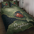Ladybug quilt blanket displayed on a bed with leafy green artwork and red beetle accents
