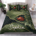 Ladybug quilt bedding styled in a bright bedroom with green leaves and red beetle artwork