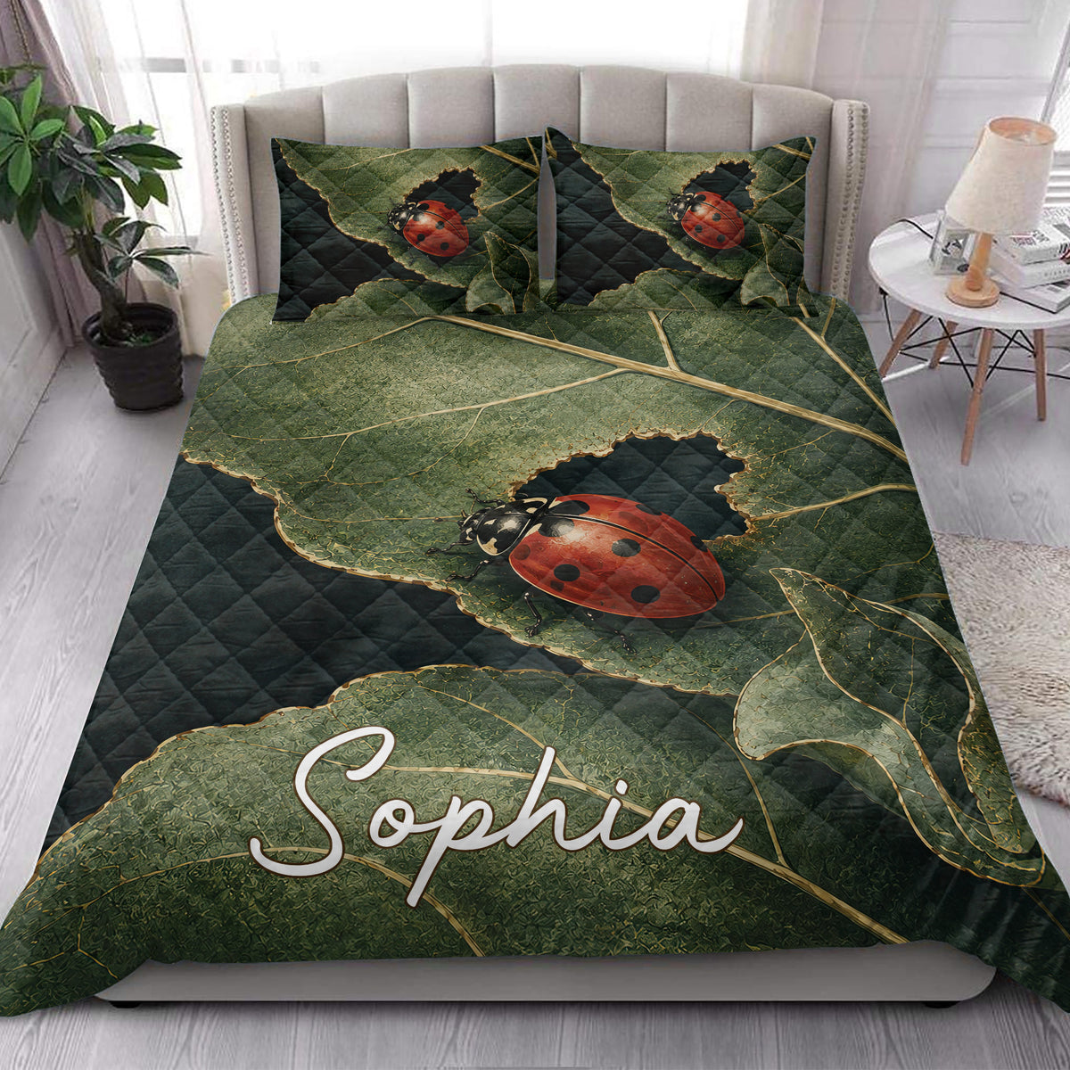 Ladybug quilt bedding styled in a bright bedroom with green leaves and red beetle artwork