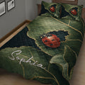 Close bedroom view of a ladybug quilt blanket featuring detailed leaves and red beetles