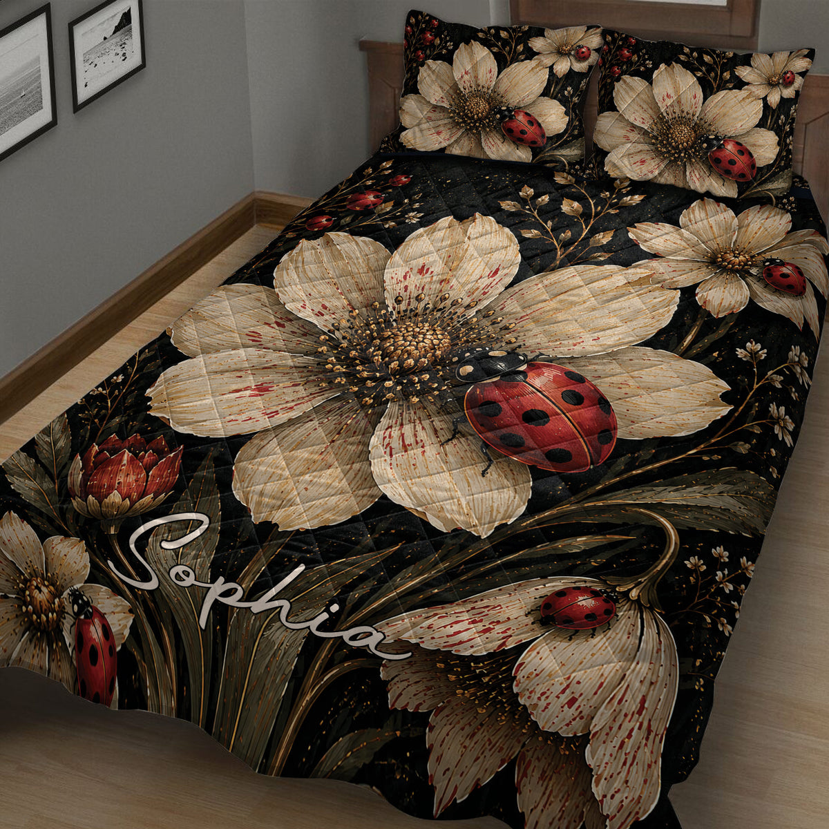 Close view of ladybug quilt blanket artwork with cream flowers, leafy branches, and a black background