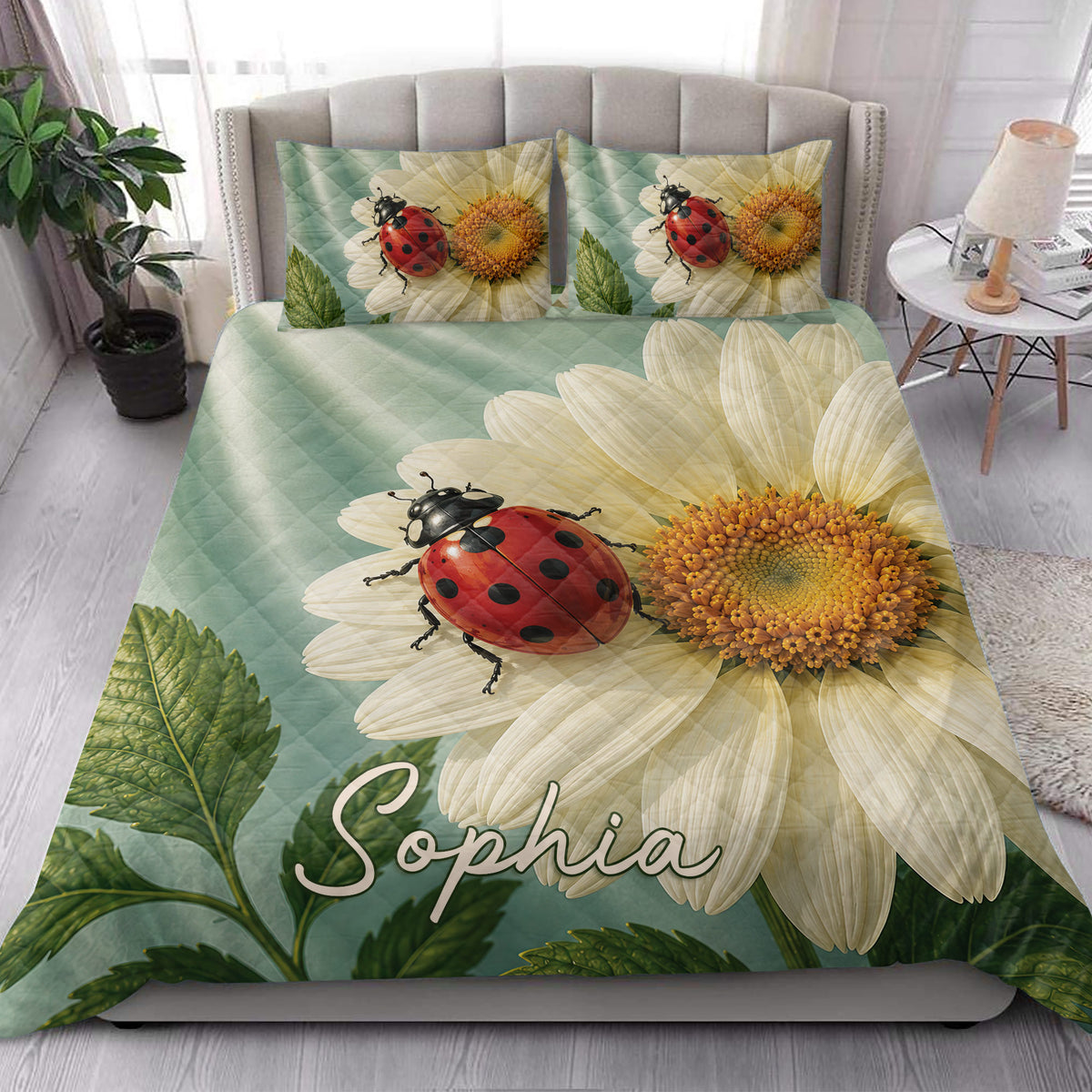 Ladybug and daisy quilt bedding styled in a bright bedroom with botanical green and teal accents