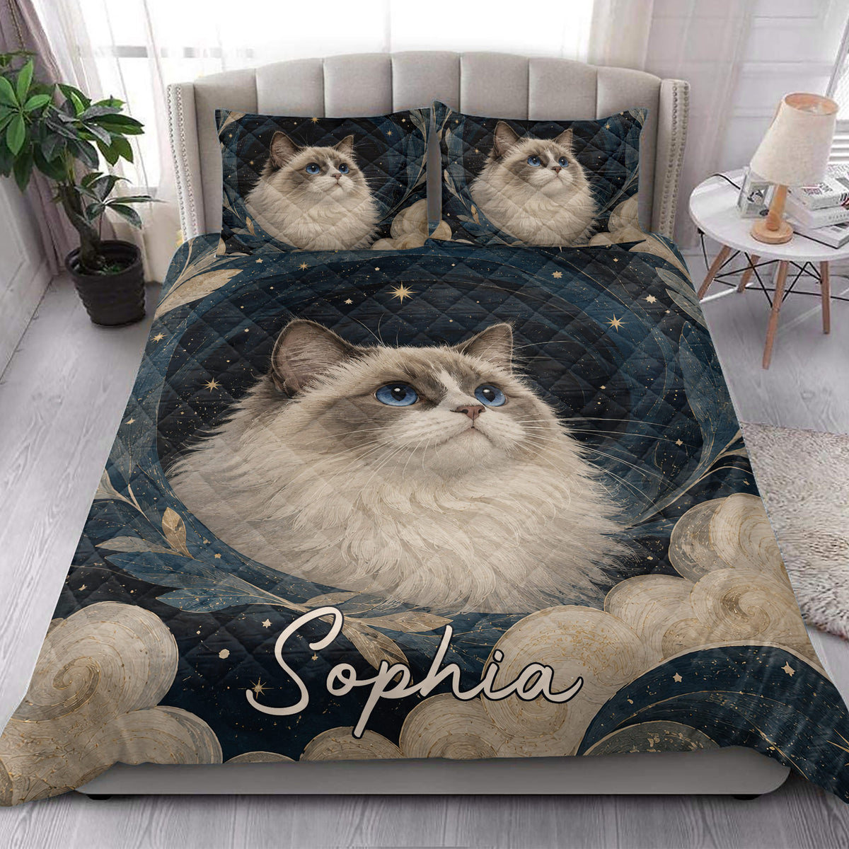 Ragdoll cat quilt blanket styled on a bright bedroom bed with matching cat artwork on the pillows