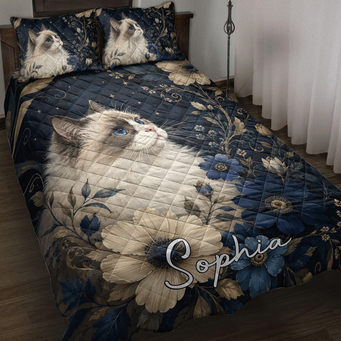 Ragdoll cat quilt blanket displayed on a bed with blue flowers, stars, and dark navy botanical artwork