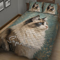 Close bedroom view of a Ragdoll cat quilt blanket with blue eyes, teal tones, and botanical accents