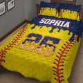 Close-up view of a softball quilt blanket with yellow, navy, and red artwork