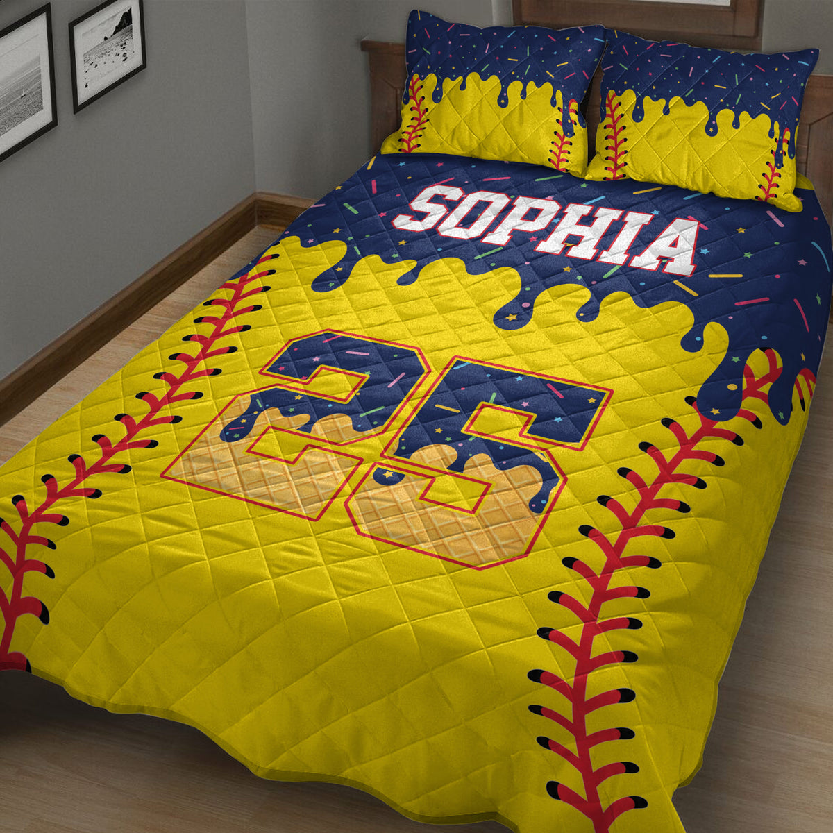 Close-up view of a softball quilt blanket with yellow, navy, and red artwork