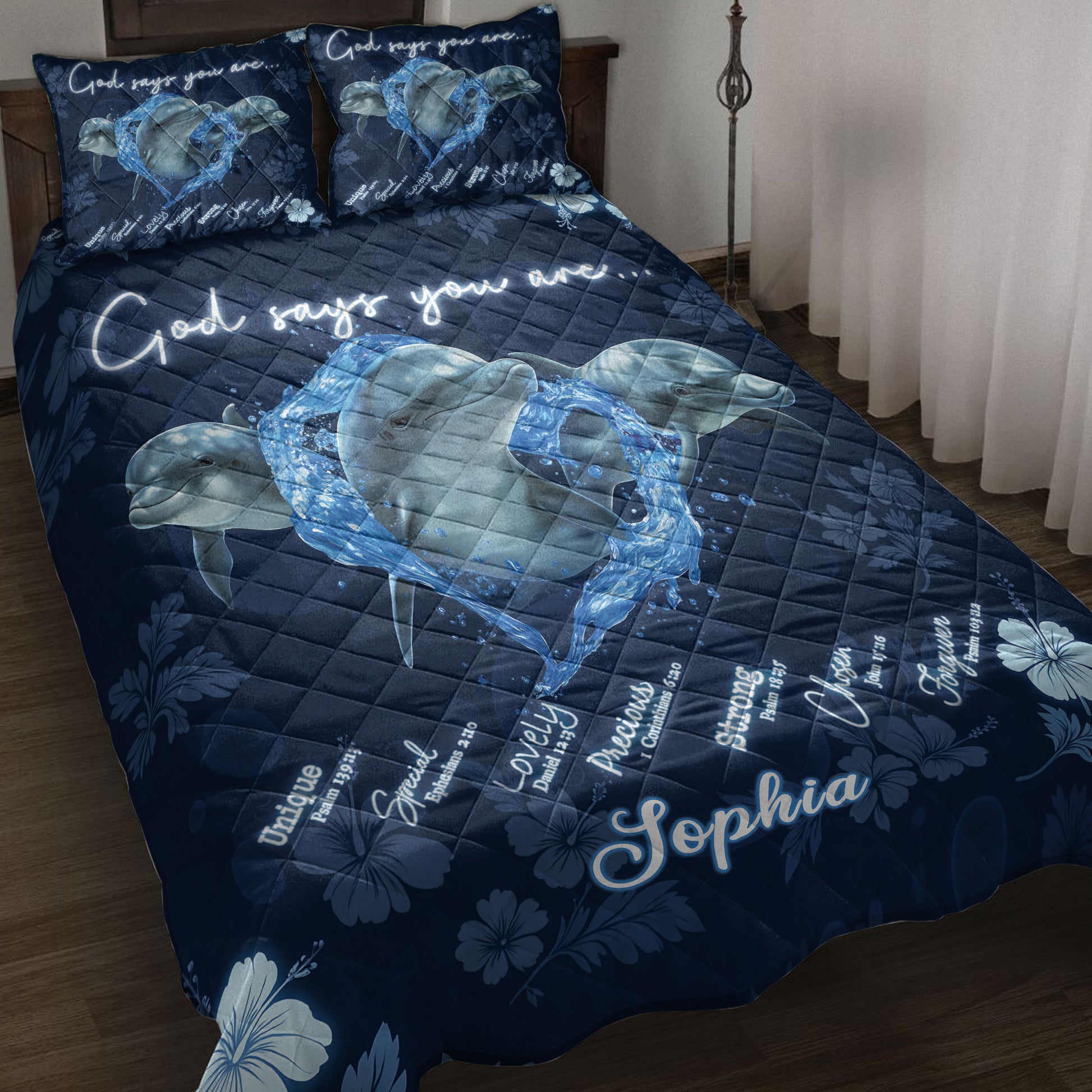 Navy dolphin quilt blanket displayed on a bed with water-splash artwork, floral accents, and inspirational messaging