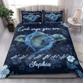 Ocean-themed dolphin quilt blanket styled on a bedroom bed with matching dolphin artwork and navy floral decor