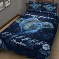 Close bedroom view of a navy dolphin quilt blanket featuring swimming dolphins, water splashes, flowers, and inspirational art