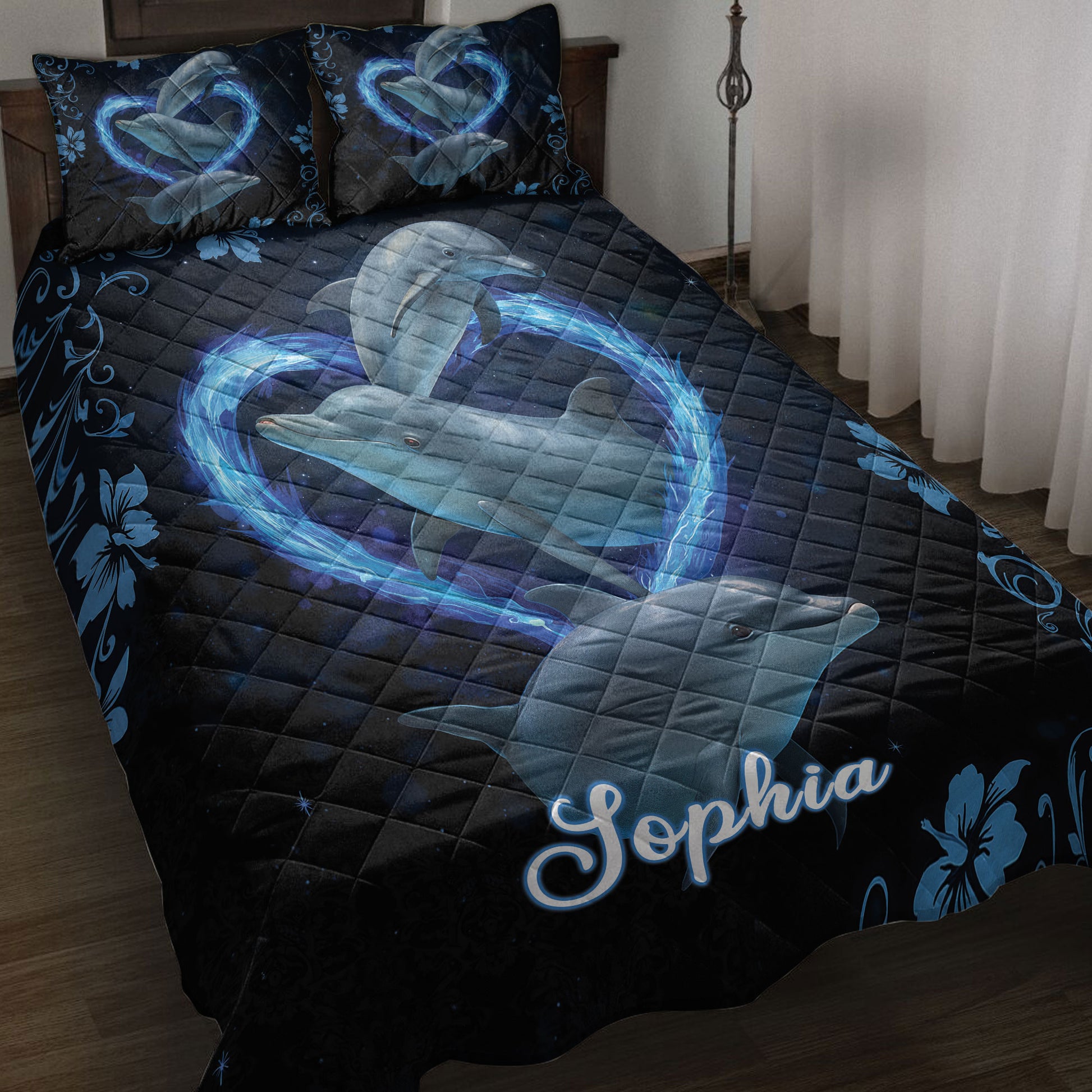 Dolphin quilt blanket featuring blue dolphins, glowing wave hearts, floral accents, and a dark navy background