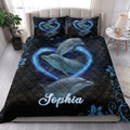 Dolphin quilt bedding styled on a bedroom bed with blue wave hearts and dark ocean artwork