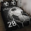 Black and white soccer quilt blanket displayed on a bed with soccer ball net artwork