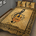 Close bedroom view of a gold guitar quilt blanket surrounded by musical notes and staff lines