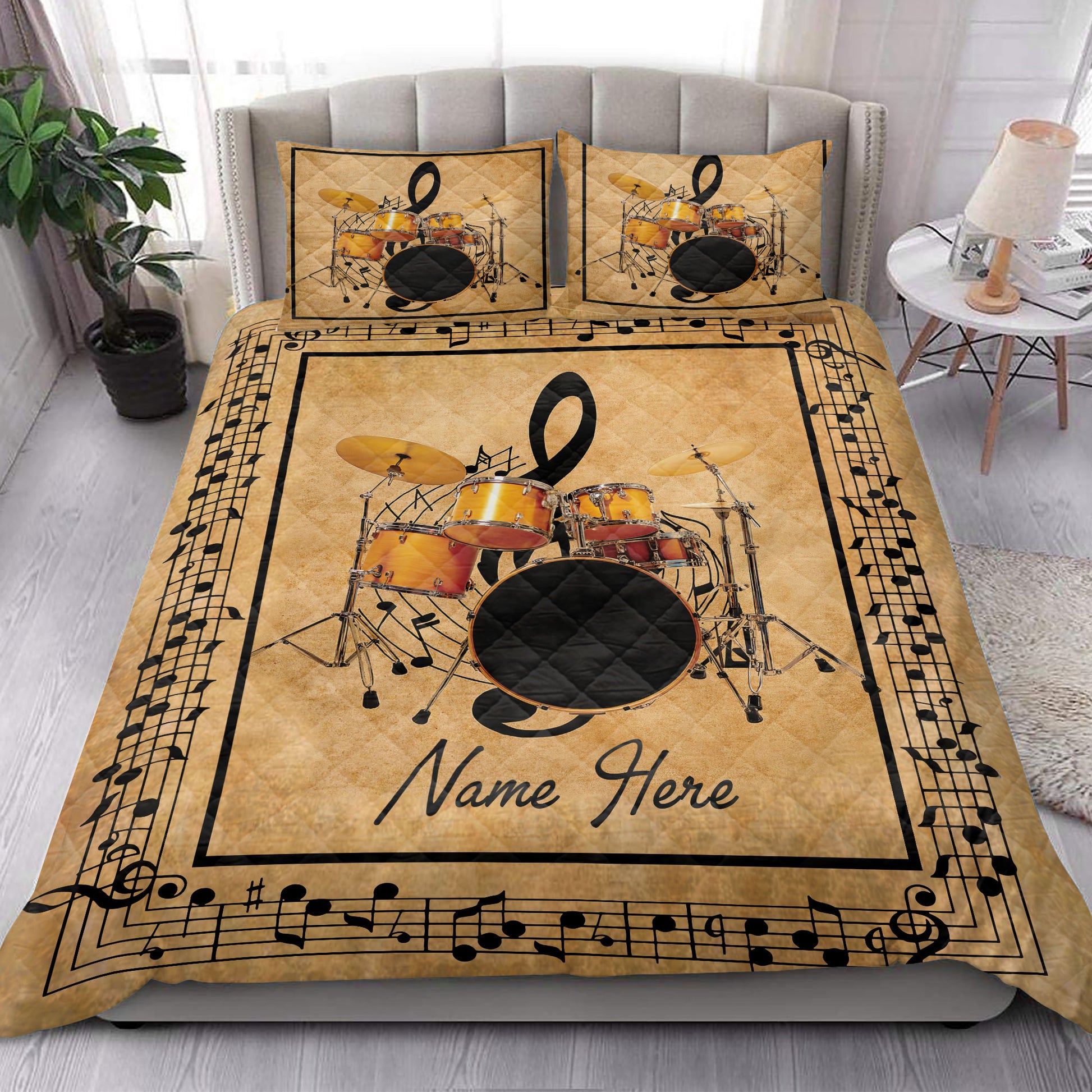 Drum set quilt bedding styled in a bright bedroom with gold musical artwork and printed pillows