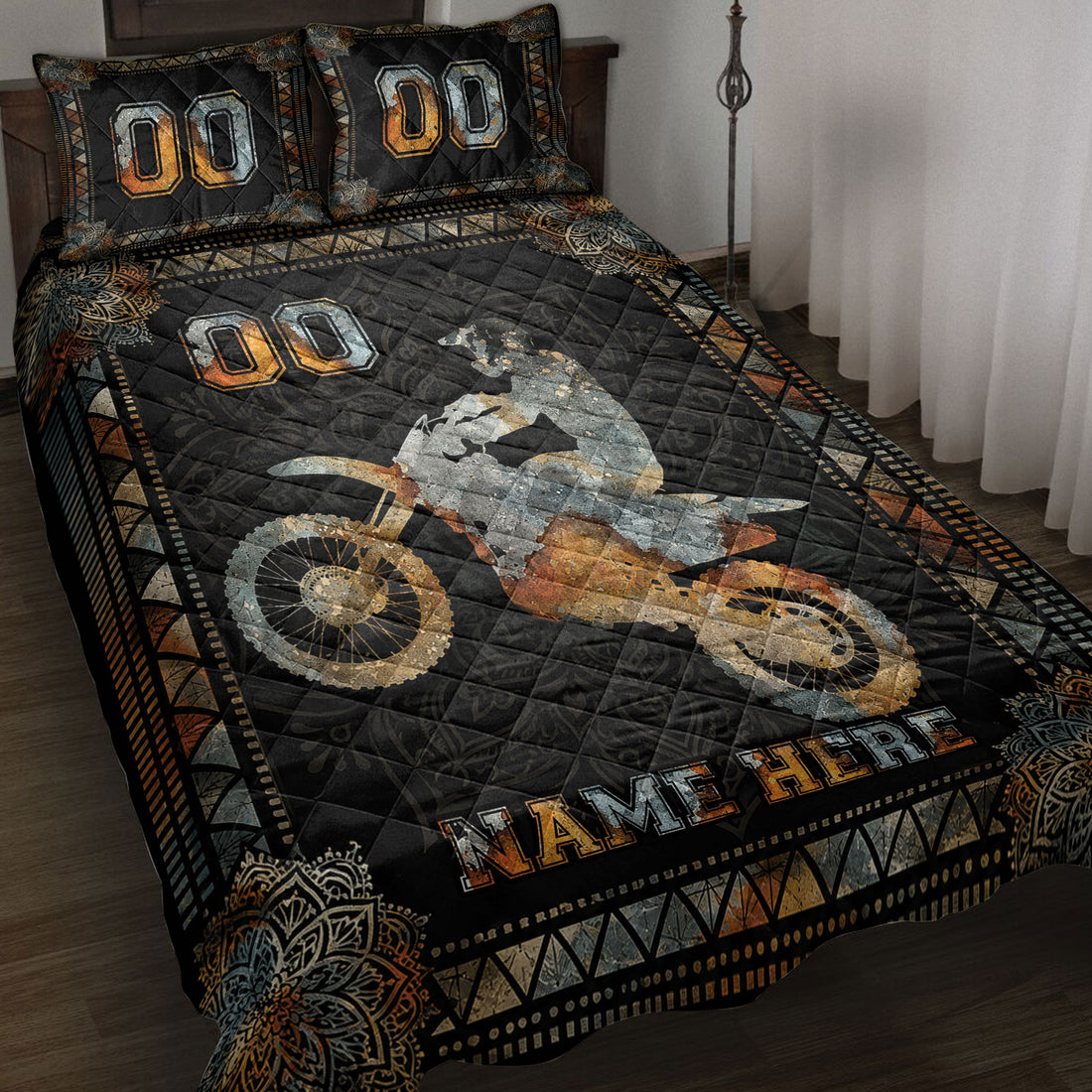 Motocross quilt blanket displayed on a bed with dirt bike rider artwork in black, orange, and silver