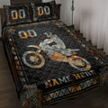 Motocross quilt blanket displayed on a bed with dirt bike rider artwork in black, orange, and silver