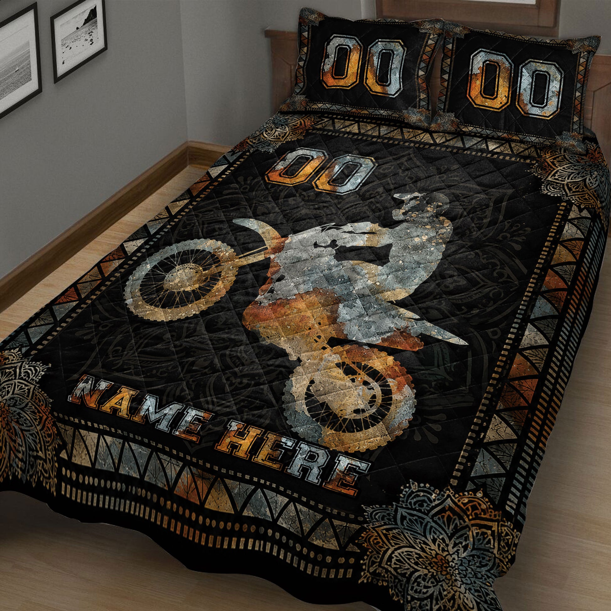 Close view of motocross quilt bedding with rider, dirt bike wheels, and black orange geometric artwork