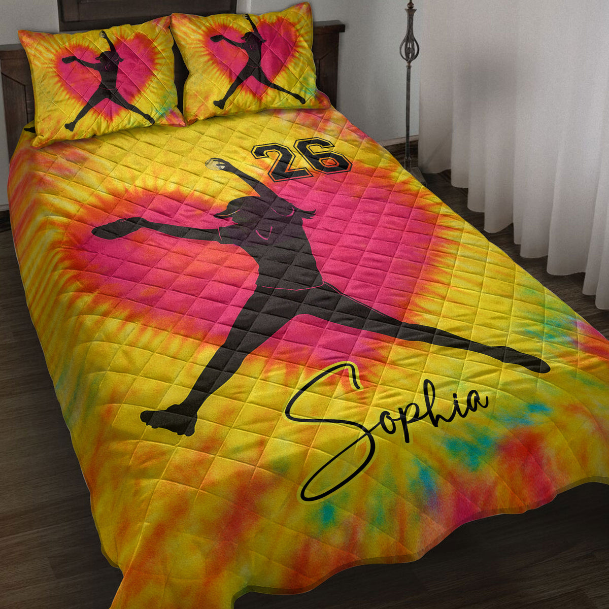 Colorful softball quilt blanket on a bed with female player silhouettes and vibrant tie-dye sports artwork