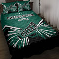 Green, black, and white cheerleader quilt blanket styled on a bed with bold pom-pom artwork