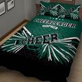Close bedroom view of a green cheerleader quilt blanket with bold black and white pom-pom design