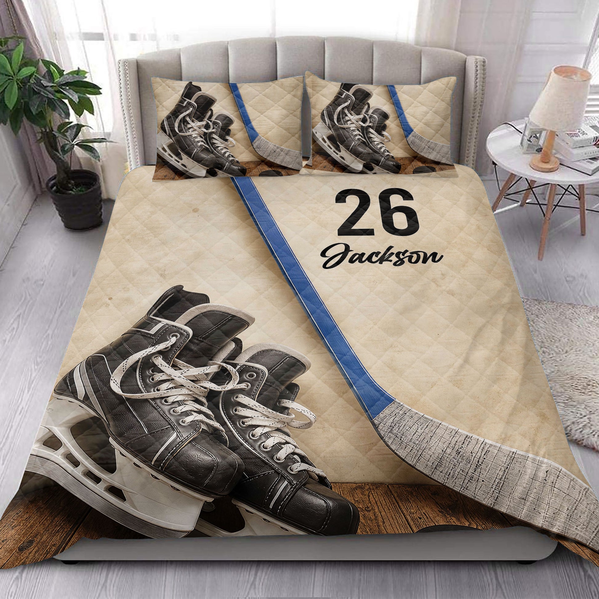 Hockey quilt bedding styled in a bright bedroom with skates, sticks, and blue accents