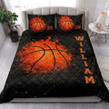 Basketball quilt bedding set styled on a bedroom bed with bold orange and black sports artwork