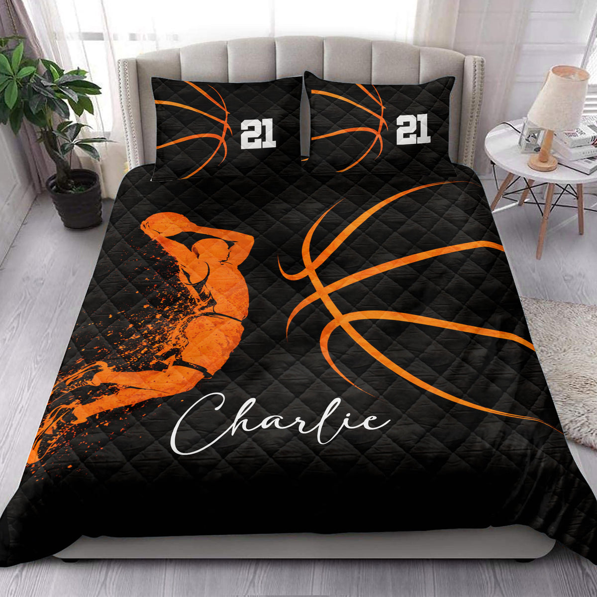 Black and orange basketball quilt blanket displayed in a bright bedroom with basketball artwork