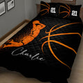 Close bedroom view of a black basketball quilt blanket with orange basketball graphics