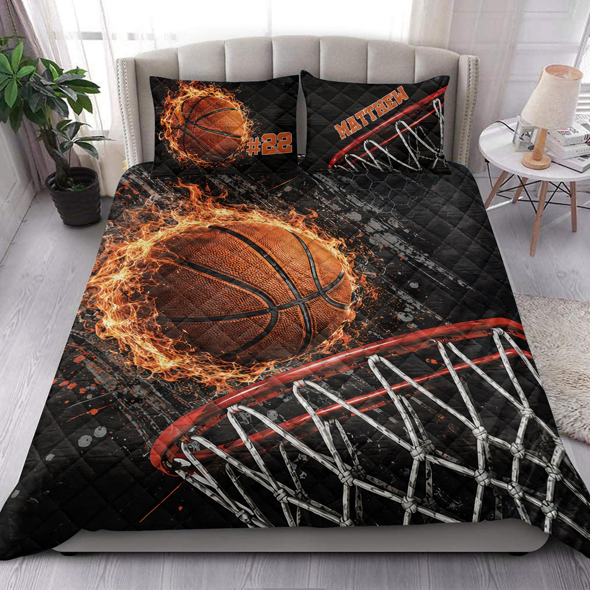 Basketball quilt blanket styled on a bedroom bed with dramatic black, orange, and red sports artwork