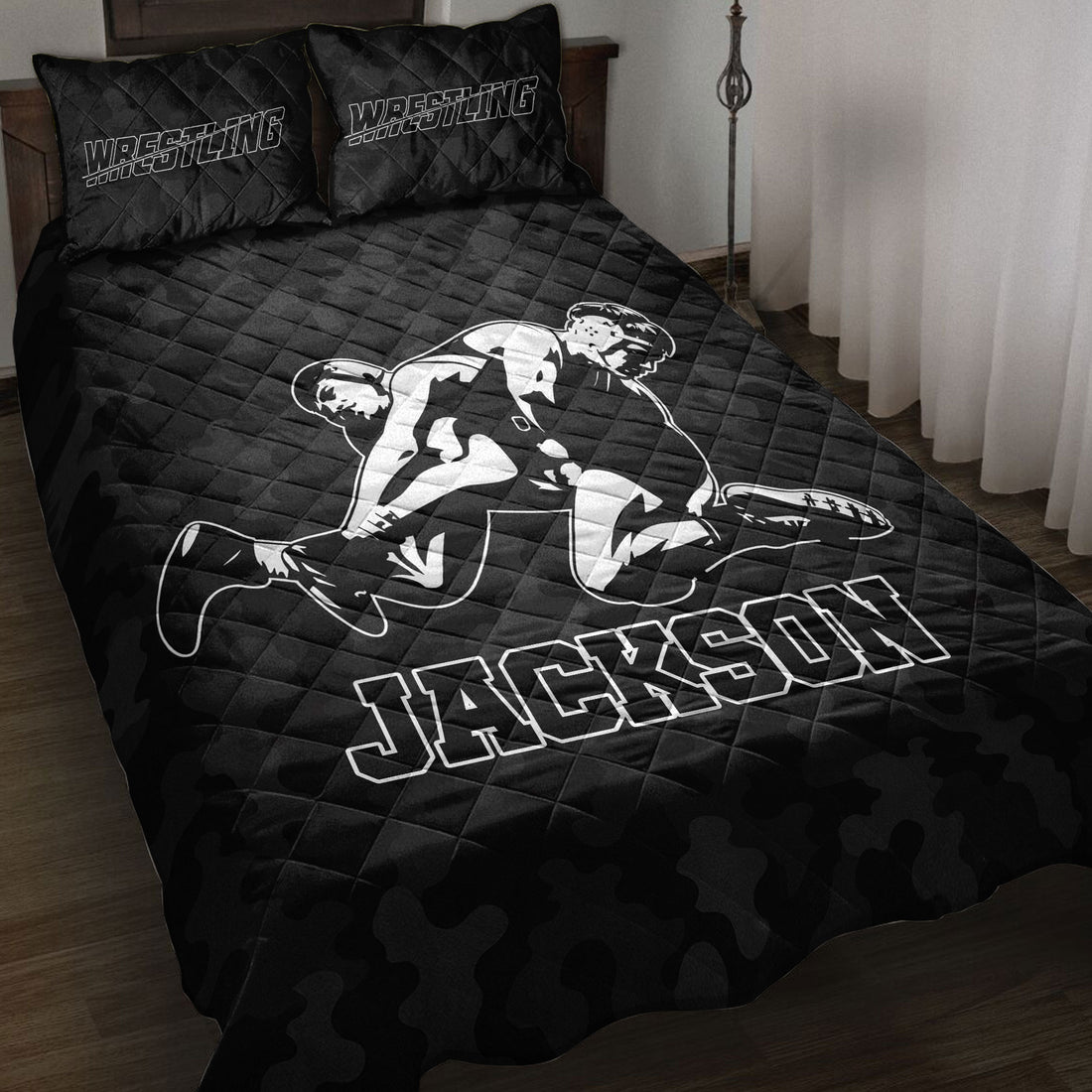 Black wrestling quilt blanket displayed on a bed with grappling artwork and bold sports lettering