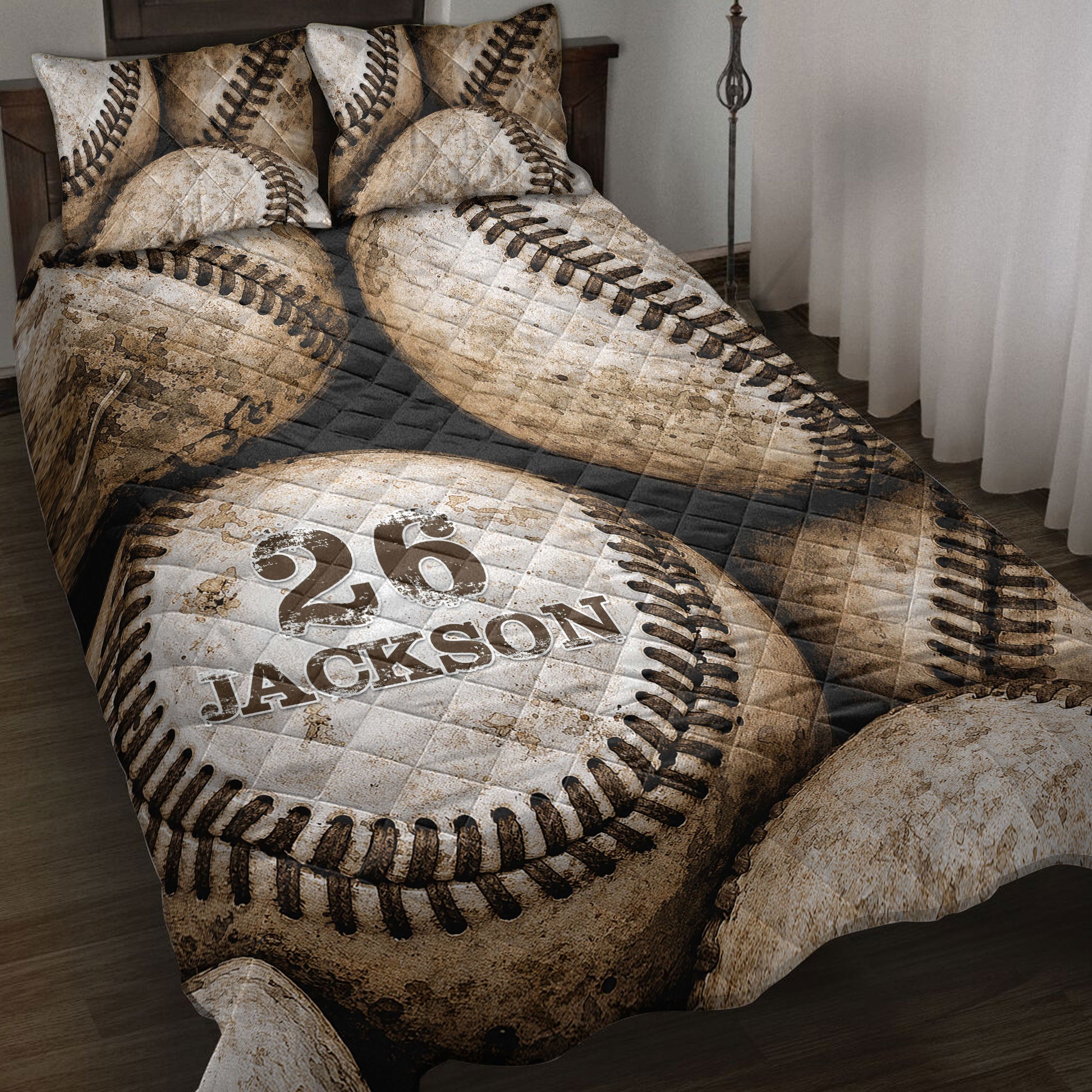 Baseball quilt blanket spread across a bed with vintage baseball artwork and dark quilted accents