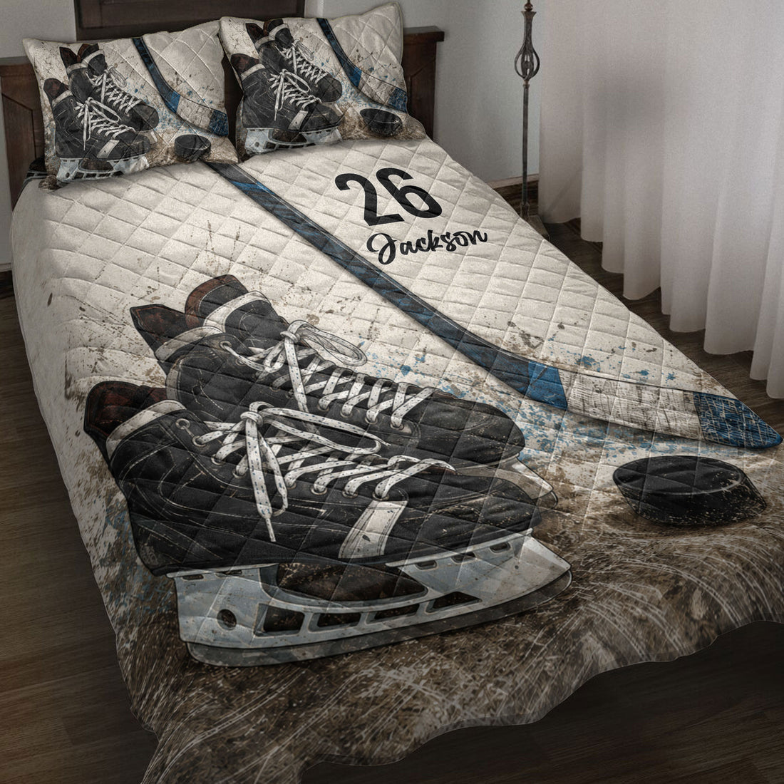 Hockey quilt blanket displayed on a bed with skates, sticks, pucks, and blue sports accents