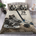 Hockey quilt blanket styled in a bright bedroom with skate, stick, and puck artwork