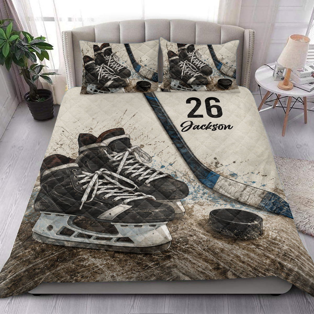 Hockey quilt blanket styled in a bright bedroom with skate, stick, and puck artwork