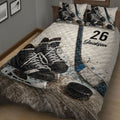 Close view of hockey quilt bedding with black skates, blue stick accents, and puck graphics