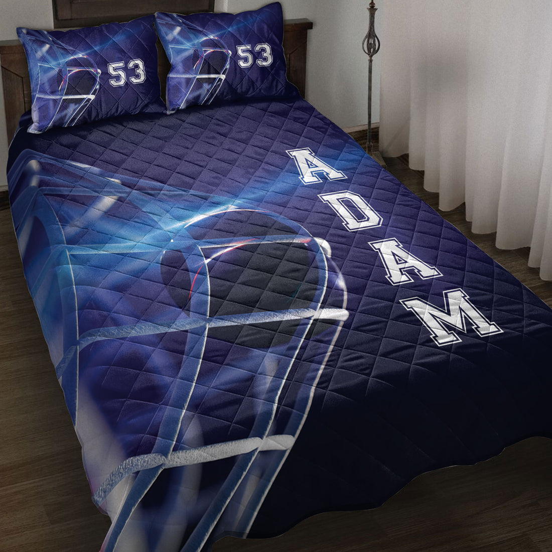Blue hockey quilt blanket styled on a bed with helmet artwork, bold rink-inspired graphics, and pillow options