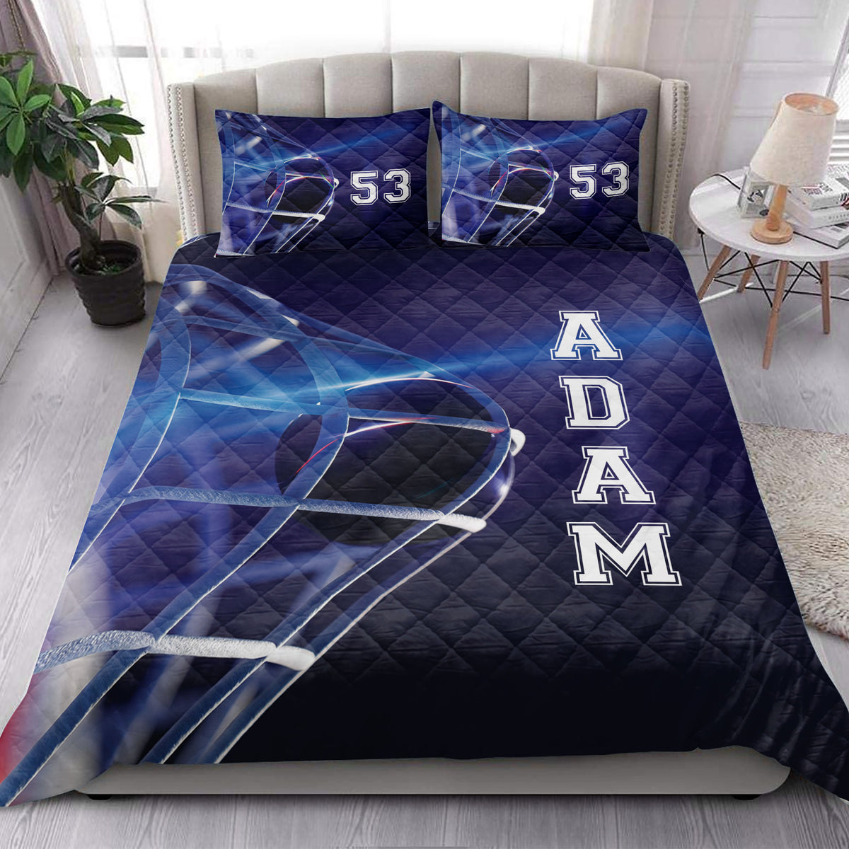 Hockey quilt bedding styled in a bright bedroom with blue helmet artwork and bold sports-inspired graphics