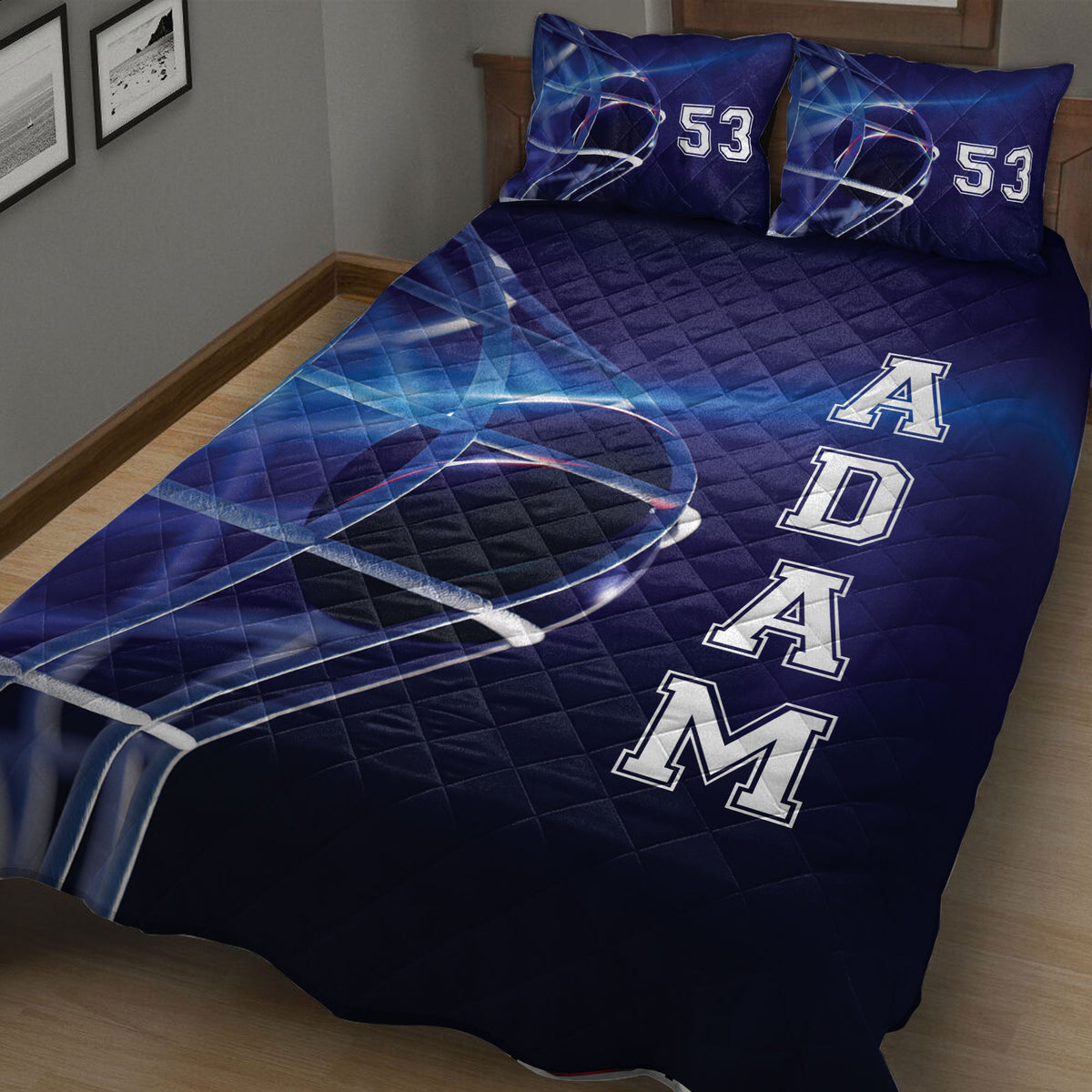 Close bedroom view of a navy hockey quilt blanket with helmet artwork and dynamic blue rink-inspired lines