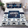 Hockey quilt bedding styled in a modern bedroom with bold navy, cyan, and white stick and puck graphics