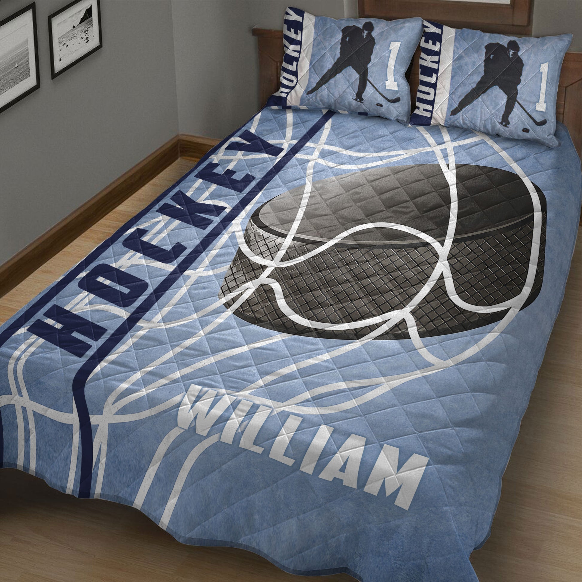 Close bedroom view of a blue hockey quilt blanket featuring oversized hockey equipment graphics and player silhouettes