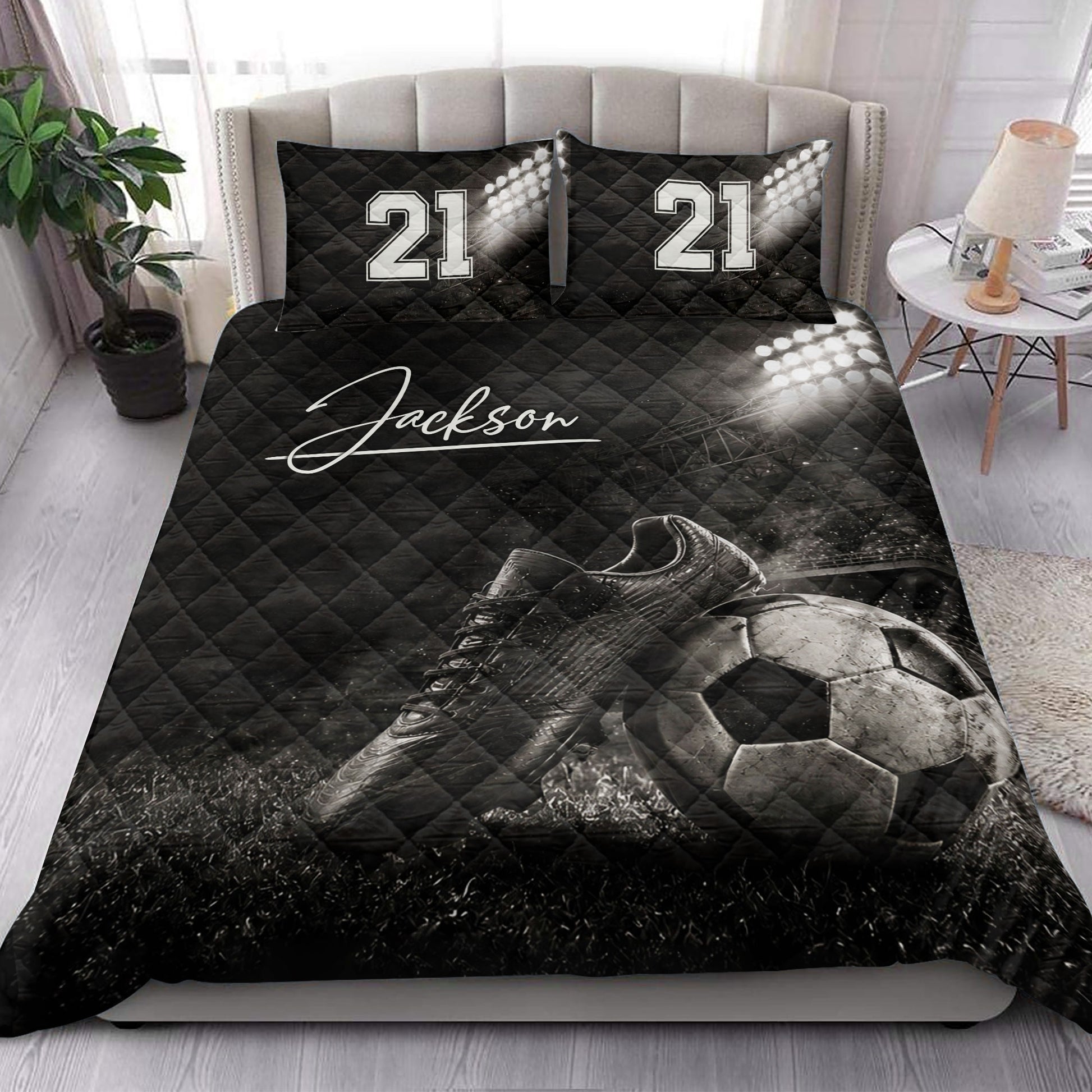 Soccer quilt bedding styled on a bedroom bed with cleats, soccer ball, and stadium light artwork