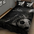 Close view of black soccer quilt blanket featuring cleats, soccer ball, grass, and stadium lights