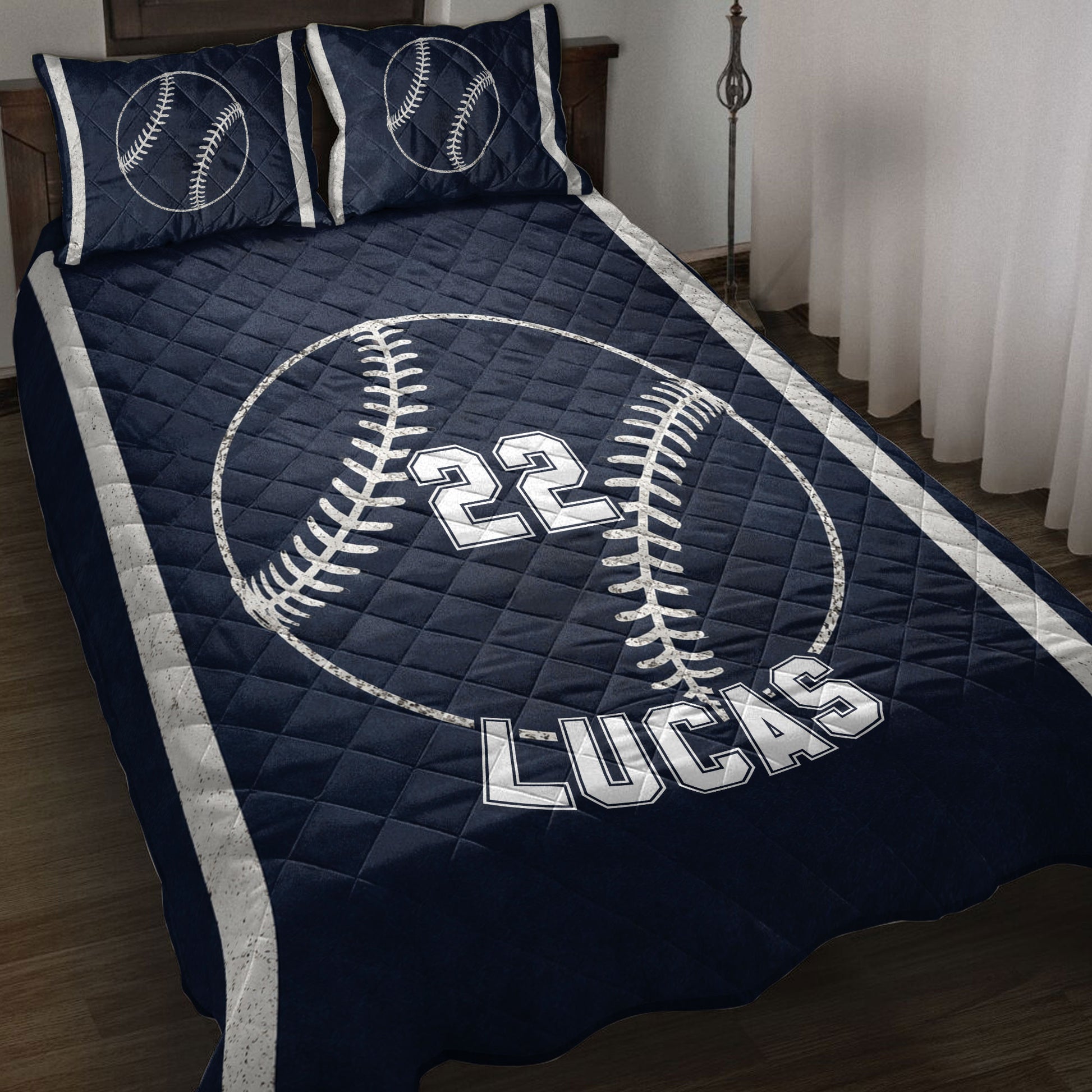 Navy baseball quilt blanket displayed on a bed with baseball artwork and bold sports-style design