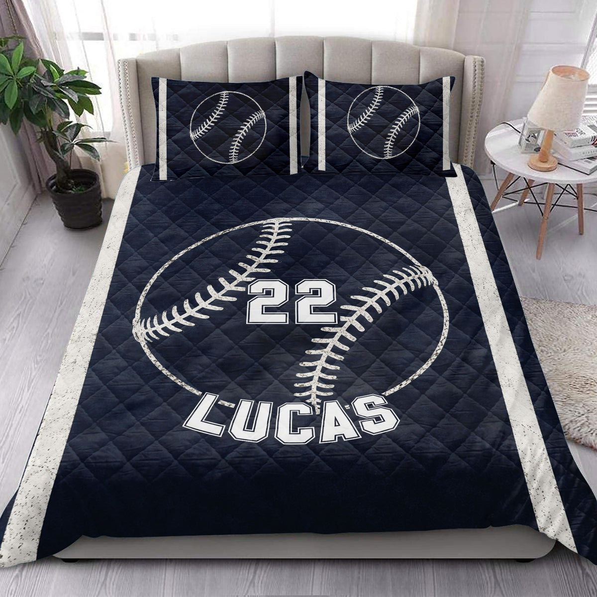 Navy baseball quilt blanket styled in a bright bedroom with matching baseball pillow designs