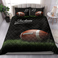 American football quilt blanket styled on a bed with black diamond quilting and vivid field artwork