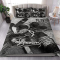 Hockey quilt blanket styled in a bedroom with dramatic black and white hockey equipment artwork