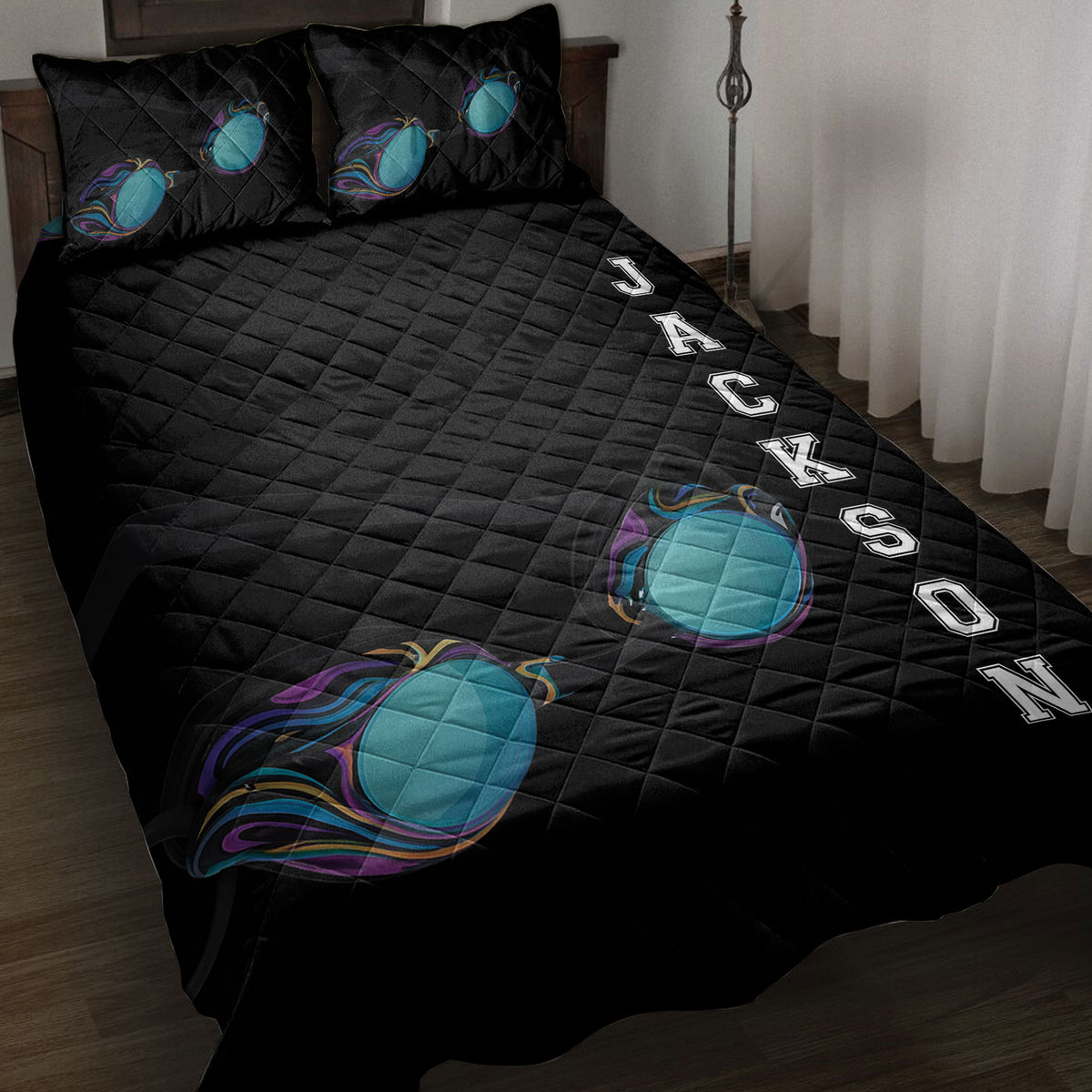 Black swimming quilt blanket displayed on a bed with colorful swim goggles and bold sports artwork