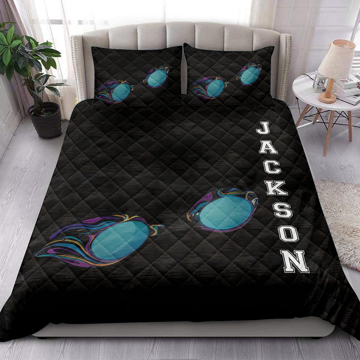 Swimming-themed black quilt blanket styled on a bedroom bed with colorful goggles and bold athletic artwork
