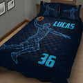 Navy basketball quilt blanket displayed on a bed with glowing sports artwork